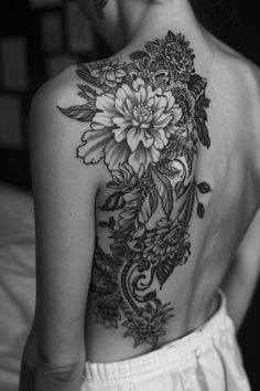 A person with an intricately detailed floral tattoo covering their back. Kind Tattoo