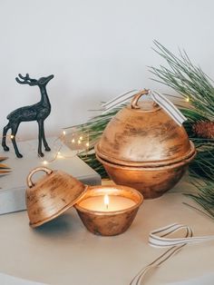 two tea lights sitting on top of a table next to a deer figurine