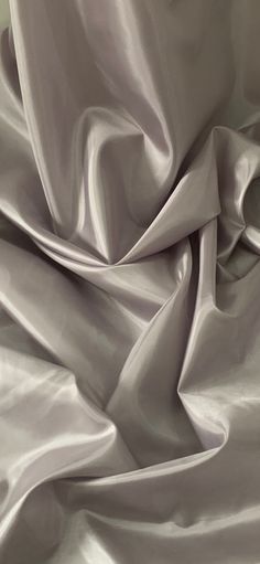 an up close shot of a white satin fabric with very soft folds and wrinkles