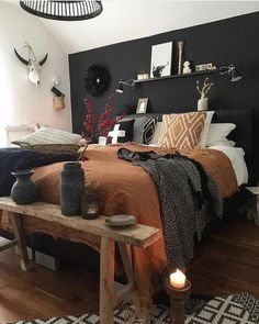 a bed room with a neatly made bed next to a wooden table and two candles