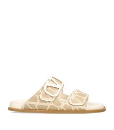 Find VALENTINO Raffia Vlogo Slides on Editorialist. These slides from Valentino Garavani combine cushioned leather insoles with upper straps adorned in the Italian Houses distinctive logo. Let their easy elegance complement your off-duty vacation looks or pare back a glamorous evening ensemble. Finished with a signature 'V', therell be no doubt as to where your brand allegiances lie. Luxury Slides With Textured Footbed For Spring, Luxury Slip-on Slides For Spring, Luxury Flat Slides With Buckle Closure, Luxury Slides With Buckle Closure, Luxury Summer Sandals With Logo, Luxury Sandals With Textured Footbed For Vacation, Luxury Sandals With Buckle Closure For Vacation, Luxury Summer Slides With Buckle Closure, Designer Summer Slides With Removable Insole