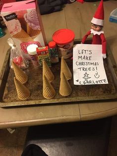 an elf is sitting on top of a tray with cones and ice cream in front of him