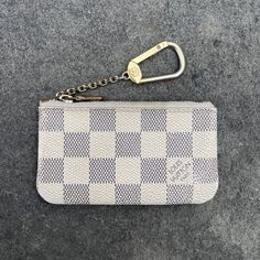 a white and blue checkered purse with a keychain hanging from it's side