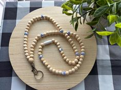 a wooden beaded necklace on a table next to a potted plant and keychain