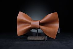 ✨Be stylish and unique with a Genuine Leather Bow Tie! ✨ It's a great accessory for wedding or any other special occasion. This item will give you confidence during all event, you will no longer be worried about your appearance, because  wearing this bow tie you will look just perfectly 🎀MATERIALS: Our Bow ties are made of 100% Full Grain Leather made in Italy.  100% Handmade accesories. Minimalist design, unisex. 🎀SIZE: - 6x11 cm. (2.3x4.3") - strap is regulated; - the width of strap is 1.5 c Classic Bow Tie For Suit Accessories As Gift, Classic Detachable Bow As A Gift, Classic Bow Tie For Gifts, Classic Bow Tie Gift, Classic Ties With Bow Tie Back For Gifts, Adjustable Bow Tie For Gifts, Adjustable Bow Tie For Suit As Gift, Suit And Tie Accessories With Butterfly Knot For Gifts, Brown Bow Tie For Father's Day Gift