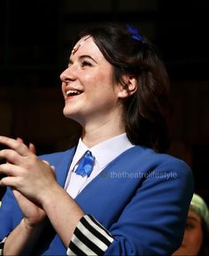 a woman wearing a blue jacket and white shirt