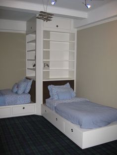 there are two beds in this room with built - in bookcases