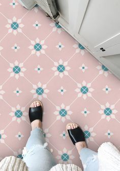 a person standing in front of a pink and blue wallpaper