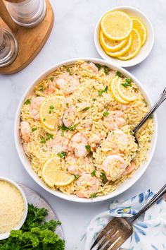 shrimp and rice in a bowl with lemons, parsley and garlic on the side