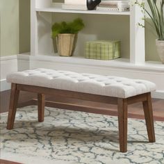 a white bench sitting in front of a book shelf