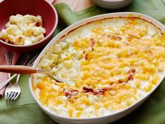 a casserole dish with potatoes and meat in it on a green table cloth