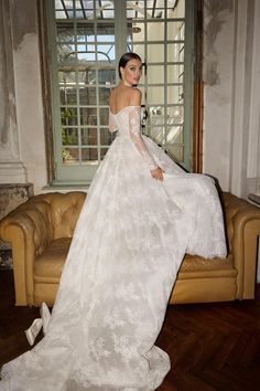 a woman in a wedding dress sitting on a couch