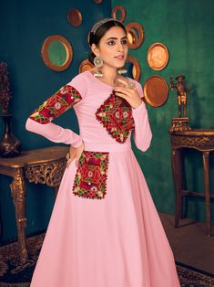 Look pretty adorning this pink color Anarkali gown in georgette material embellished with gamthi embroidery, mirror, and pearl work.
The gown comes with crepe inner material. 
The pink gown is semi-stitched can be customized up to 42 inches and the gown length is 58 inches. 
Pink color gown with gamthi work look amazing traditional can be worn at festivals like Navratri.
Disclaimer: This gown will not come with a can-can, bottom, and dupatta. Pink Embellished Kurta For Festivals, Pink Embellished Festival Kurta, Pink Kurta With Embroidered Border For Diwali, Pink Embroidered Kurta For Diwali, Pink Anarkali Set With Embroidered Border, Embellished Pink Georgette Kurta, Pink Anarkali Kurta With Mirror Work, Pink Embellished Georgette Kurta, Pink Anarkali Set With Mirror Work For Navratri