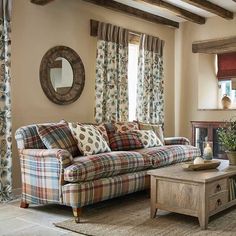 a living room filled with furniture and a fire place in front of a window covered in curtains