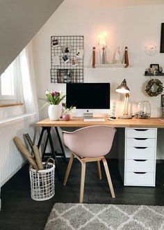 a desk with two computer monitors on top of it next to a rug and window