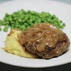 a white plate topped with mashed potatoes and meat covered in gravy