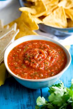 a bowl of salsa with tortilla chips on the side