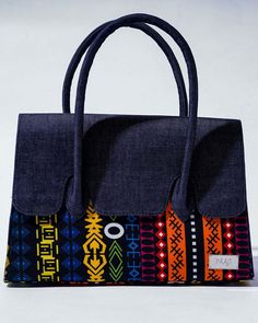 This Denim and Ankara print purse is a versatile and stylish handbag, a perfect blend of contemporary fashion and cultural vibrancy. Crafted with precision and attention to detail, this handbag is not just a fashion accessory; it's a celebration of diverse styles and cultures. The denim base provides a sturdy and durable foundation, ensuring longevity and everyday functionality. The Ankara accents, carefully selected for their vibrant hues and intricate designs, add a touch of African flair, mak Ankara Bags, Style Africain, Purse Handmade, Ankara Print, African Ankara, Printed Purse, Printed Handbags, Top Handle Bags, Handmade Bag