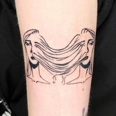 a woman's face with her hair blowing in the wind tattoo on the left arm