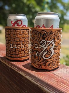 two beer cans sitting on top of a wooden table