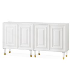 a white cabinet with gold legs and doors on the front, against a white background