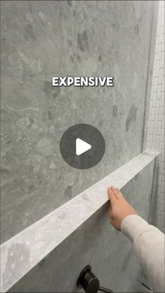 someone is opening the shower door to look at something on the wall that says expensive