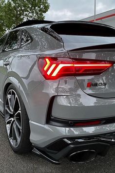 the rear end of a silver car parked in a parking lot