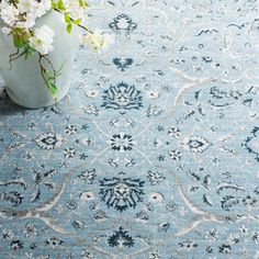 a blue rug with white flowers in a vase