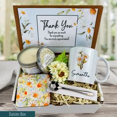 a gift box with flowers, candles and personal care items in it that says thank you