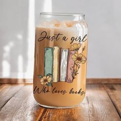 a glass filled with liquid sitting on top of a wooden table