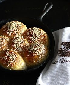 bread rolls in a cast iron skillet with salt and pepper sprinkled on top