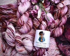 the yarn is pink and purple with flowers on it, as well as a coffee mug