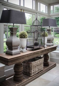 three lamps are sitting on a table in front of a window with birdcages