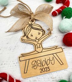 a wooden ornament that says happy new year with a girl on it and some candy