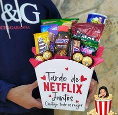 a person holding a sign that says tarde de netflix juniors and some snacks