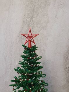 a small green christmas tree with a red star on top