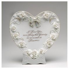 a white heart shaped plaque with roses on it