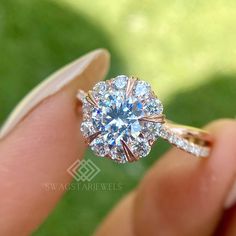 a close up of a person's hand holding a diamond ring