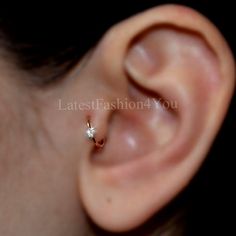 a close up of a person's ear with a small diamond in the middle