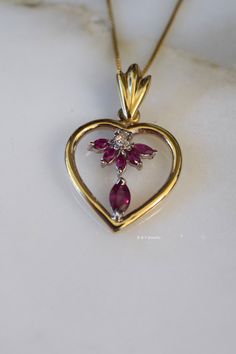 Metal: 14kt Yellow And White Gold Stone: Ruby And Diamond Shape: Marquise- Shape And Round Approximate Ruby Weight: .66 ctw Approximate Diamond Weight: .10 ctw Weight of entire piece with chain: 6.60 grams Type of Chain: .80mm Box Chain Type of Clasp: Spring Clasp Pendant Dimensions: 32.24mm long including bail, and 20.65mm wide. Length of 14kt yellow gold chain: Please select. If you don't see your desired length please state in note box at checkout. Thank you. Heirloom Oval Jewelry For Valentine's Day, Pear-shaped Jewelry For Valentine's Day Anniversary, Yellow Gold Heart Cut Ruby Jewelry, Heart Cut Ruby Jewelry In Yellow Gold, Ruby Heart Pendant Jewelry For Anniversary, Heirloom Heart Jewelry With Diamond Accents, Heirloom Heart Cut Gemstone Jewelry, Heirloom Heart-shaped Jewelry With Diamond Accents, Valentine's Day Fine Jewelry Pear-shaped