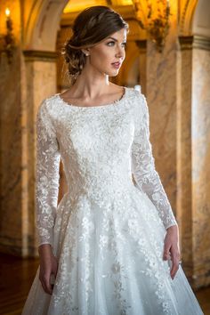 a woman in a white wedding dress with long sleeves and lace on the bouncy