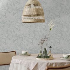 a dining room table with plates, cups and vases sitting on top of it