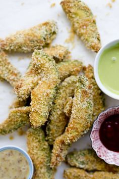 some fried food with dipping sauces on the side and another bowl full of dip