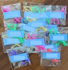 plastic bags filled with different colored toothbrushes on top of a wooden floor