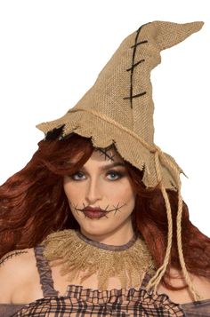 a woman with long red hair wearing a scarecrow hat and makeup on her face