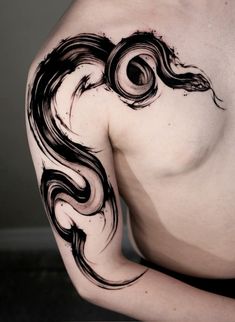 a man's chest with black ink on it and an abstract swirl design in the middle