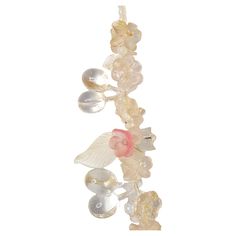 With a silver clasp that could be as old as the Victorian period and in an Art-Nouveau style with pale intricate flora motifs, this antique long glass necklace features lampwork-like hand-pressed glass that realizes pink, frosted and clear flowers, leaves, and cherries in nine stations strung along most of the lower necklace. The semi-transparent and reflective beads of various sizes and depth on the necklace, many of which are intermittently clustered via multiple darkened brass pins that each Brass Pins, Victorian Period, Unique Costumes, Brass Pin, Silk Cord, Organic Matter, Semi Transparent, Flowers Leaves, Pressed Glass