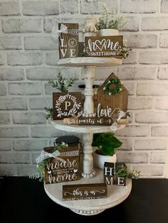 a three tiered cake with wooden signs on it