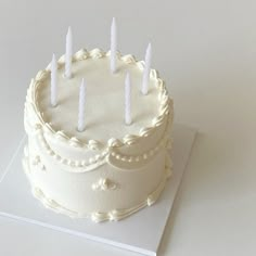 a white cake with five candles on it