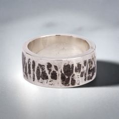 This "Kimiko" silver ring is handmade in 925 Sterling Silver in my workshop. The ring is hand crafted using a 92.5% pure silver flat piece, bent to shape, soldered, hammered and oxidized to give that special finish. The finish of this ring is inspired by the "Mokume-gane" distinctive pattern found on japanese swords. Materials: 92.5% pure solid silver Band width: 3/8 inch (10 mm) Ring size: 6 (This is a unique creation. Because of the special finish, it cannot be reproduced or resized. Only one size available. I cannot adjust the ring size) Hand Forged Wide Band Sterling Silver Ring, Hand Forged Silver Ring With Thick Band, Unique Hand Forged Sterling Silver Wide Band Ring, Hand Forged Sterling Silver Rings With Thick Band, Minimalist Hammered Sterling Silver Wide Band Ring, Hand Forged Sterling Silver Wide Band Ring As Gift, Hand Cast Wide Band Silver Sterling Ring, Hand Cast Sterling Silver Wide Band Ring, Hand Forged Sterling Silver Wide Band Ring For Anniversary